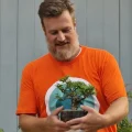 Luca Valagussa holding a bonsai